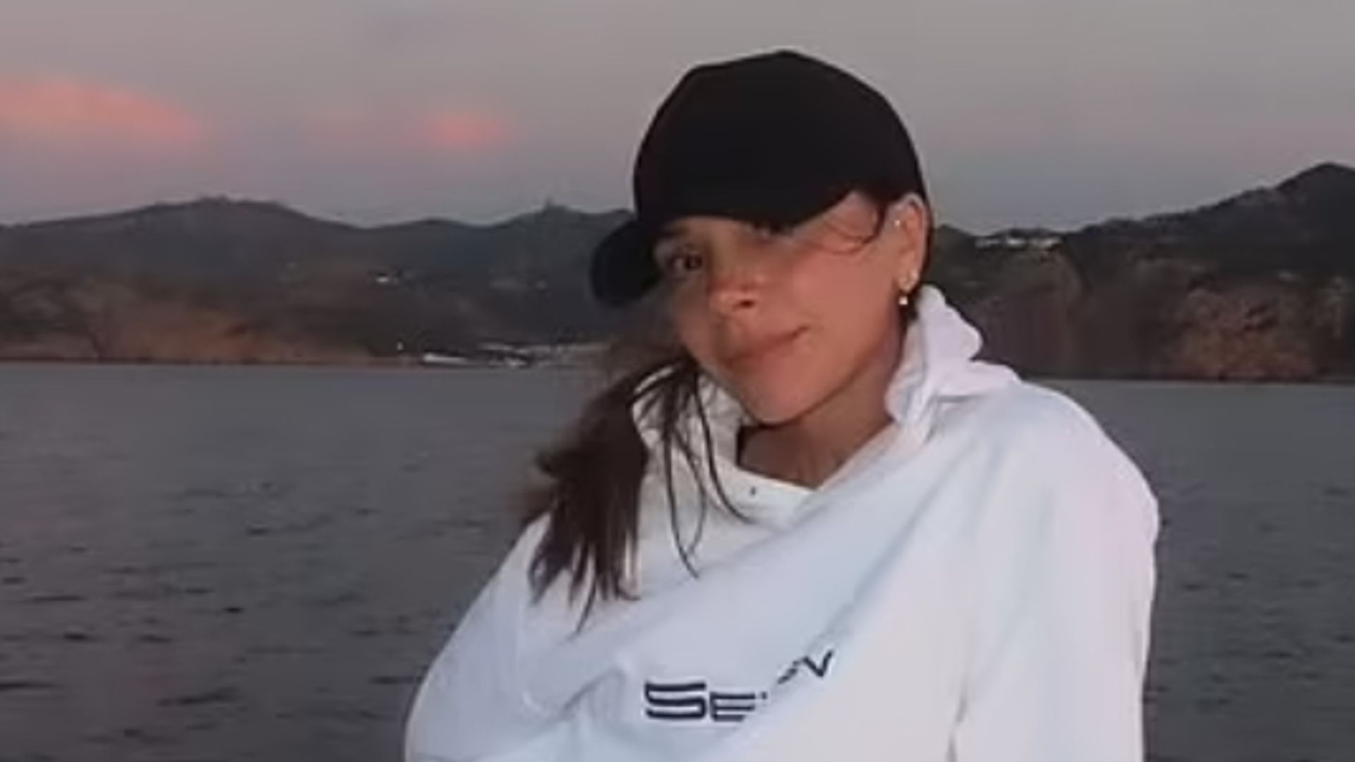 Victoria Beckham lounging on a yacht in a hoodie and black shorts