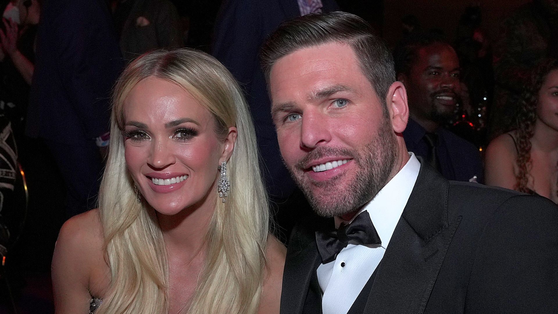 Carrie Underwood is joined by husband Mike Fisher on the red