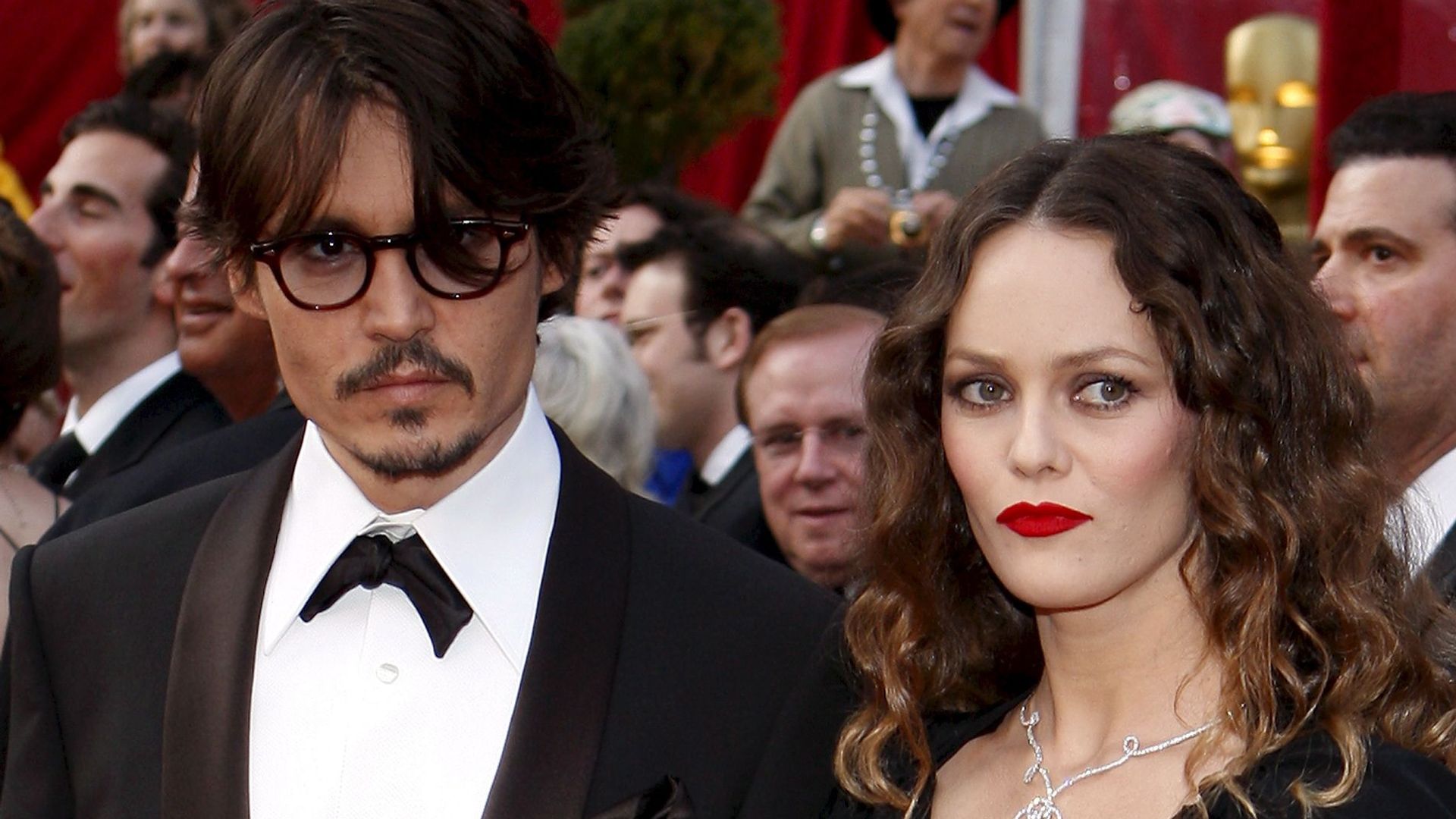 Vanessa Paradis in red lipstick with dark curls alongside Johnny Depp