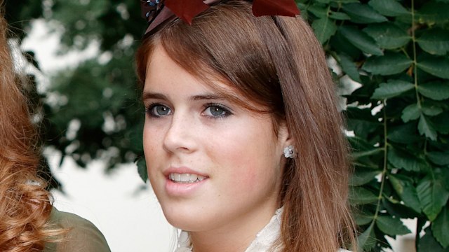 Princess Eugenie in a white dress and brown fascinator
