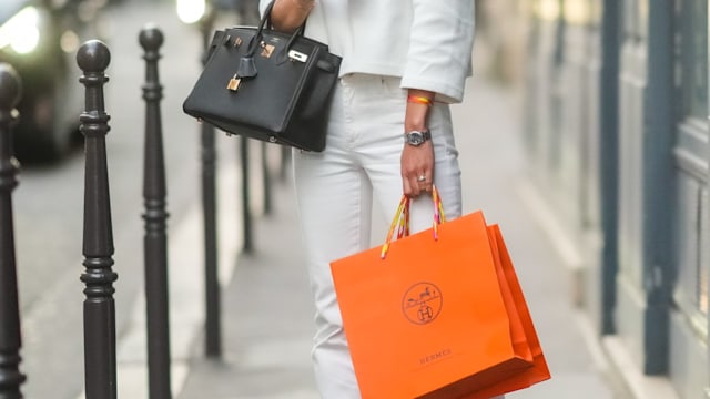  May Berthelot wears a white pullover / top, a golden necklace, a black leather Hermes Birkin bag, white ripped denim jeans pants, black shoes, holds Hermes orange shopping bags, during the Twilly By Hermes : Launch Party In Paris, on July 01, 2021 in Paris, France. (Photo by Edward Berthelot/Getty Images)