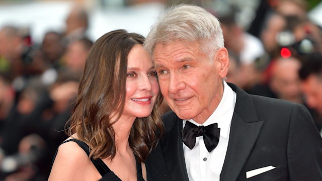 Calista Flockhart and Harrison Ford standing side by side with their heads together while posing on the red carpet at the 2023 Cannes Film Festival