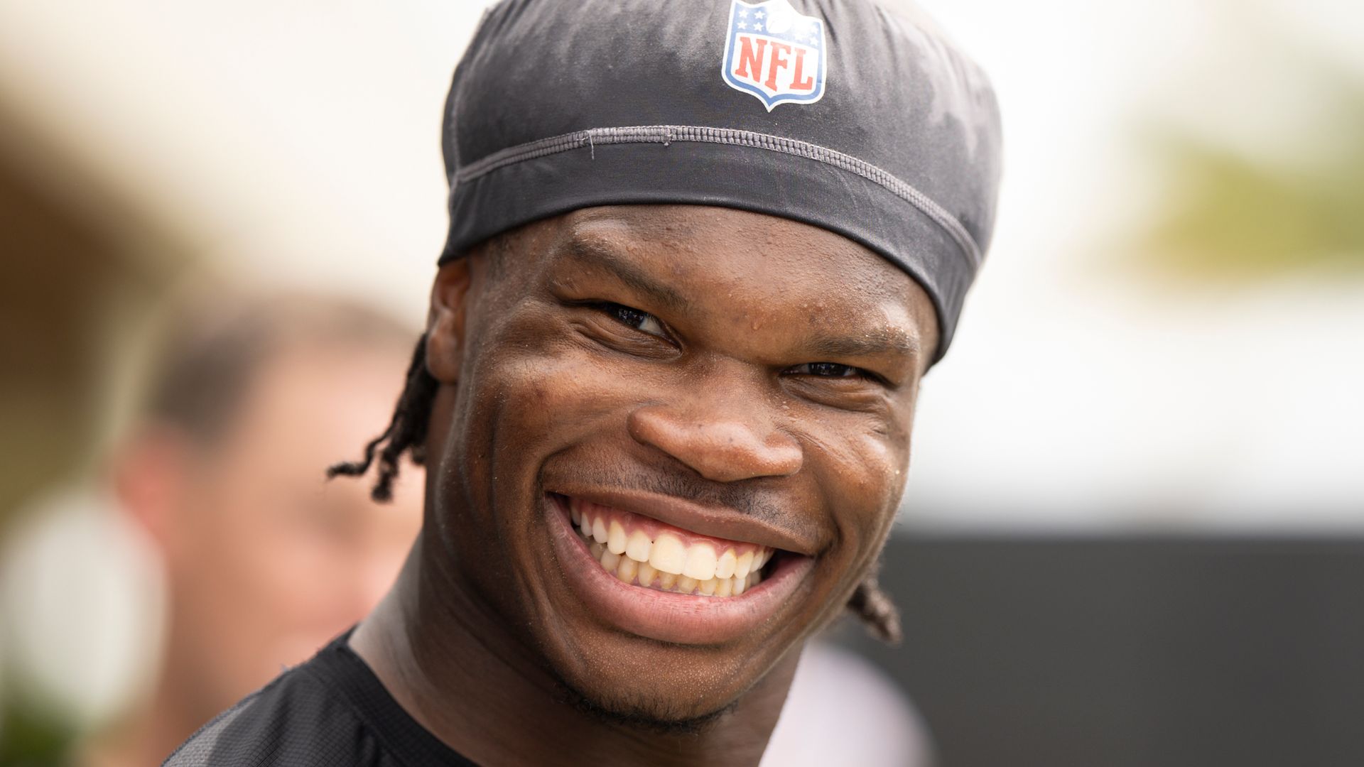 travis hunter smiling while talking into mic