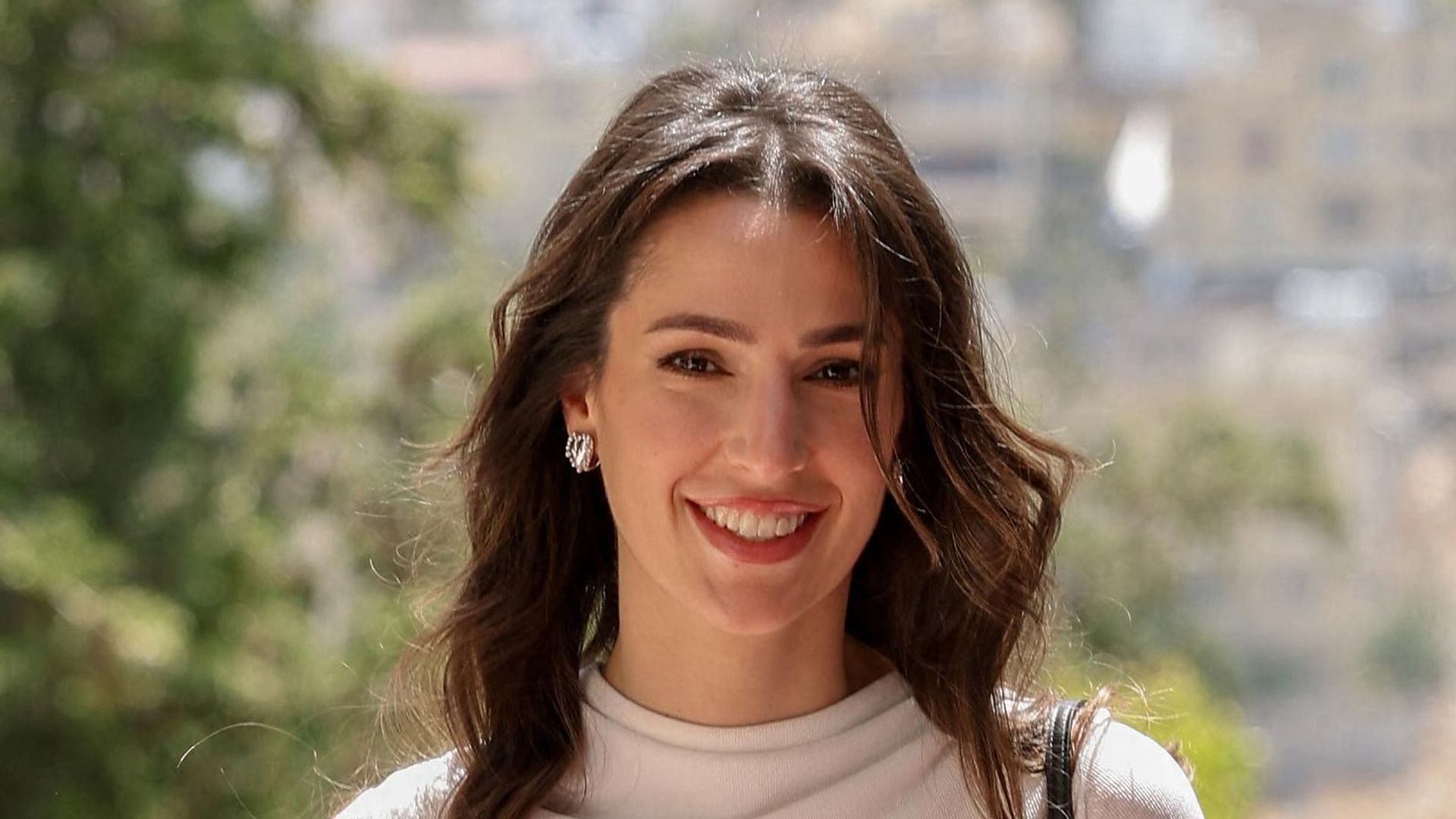 Princess Rajwa walking outside in white rollneck and skirt