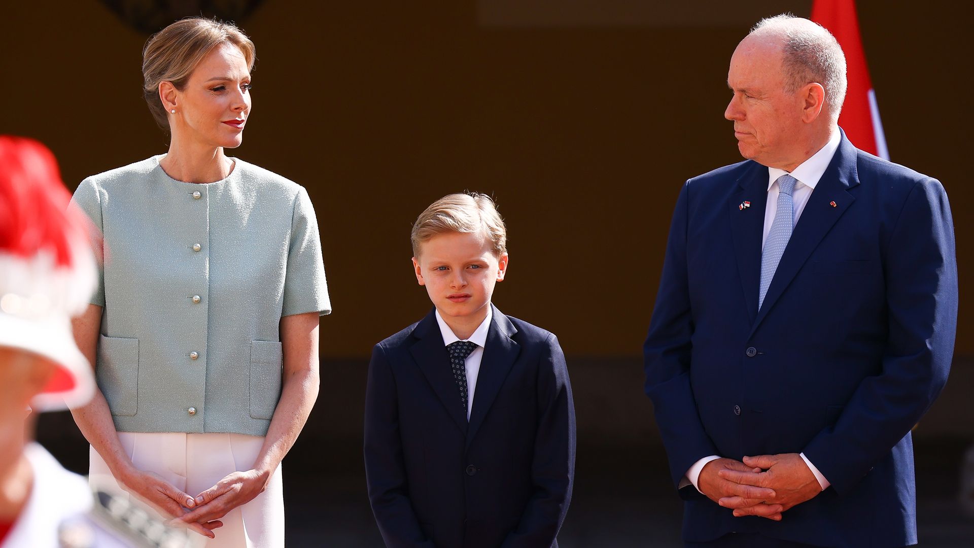 Princess Charlene standing with Prince Jacques and Prince Albert