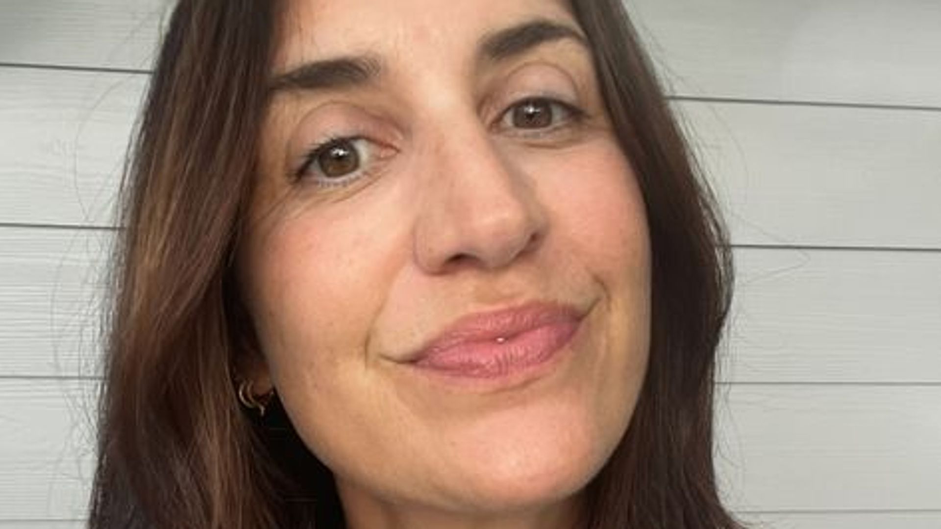 close up selfie of a woman smiling with dark brown hair