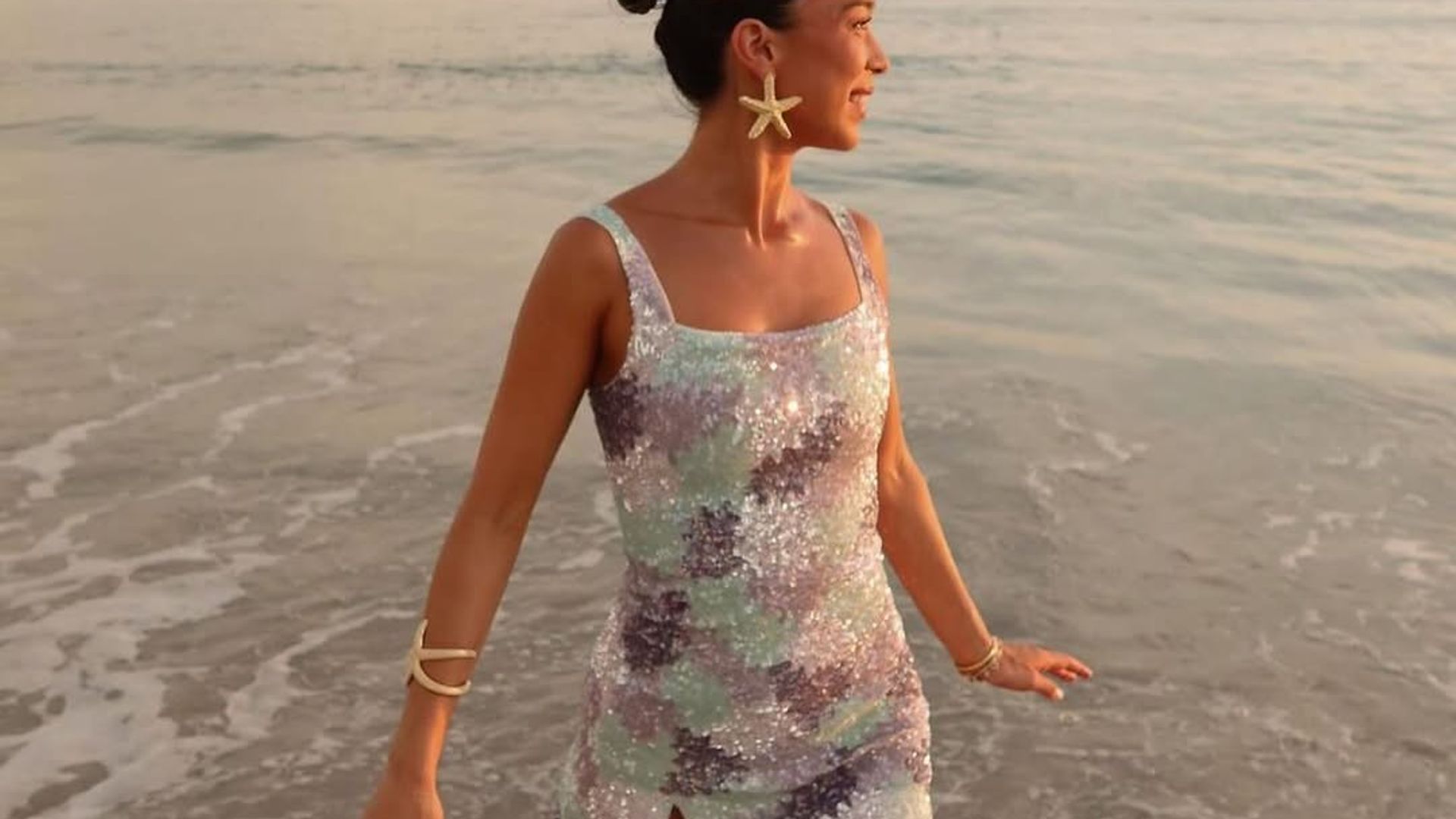 woman in sequin mini dress in the ocean