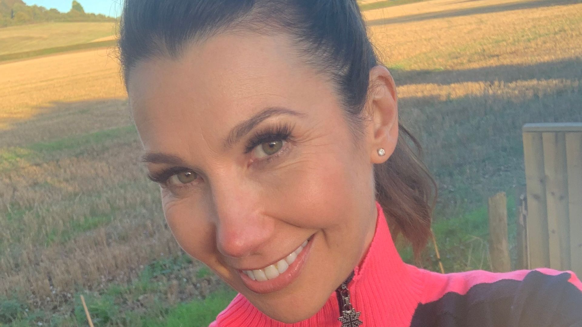 woman taking a selfie in a black and pink running top