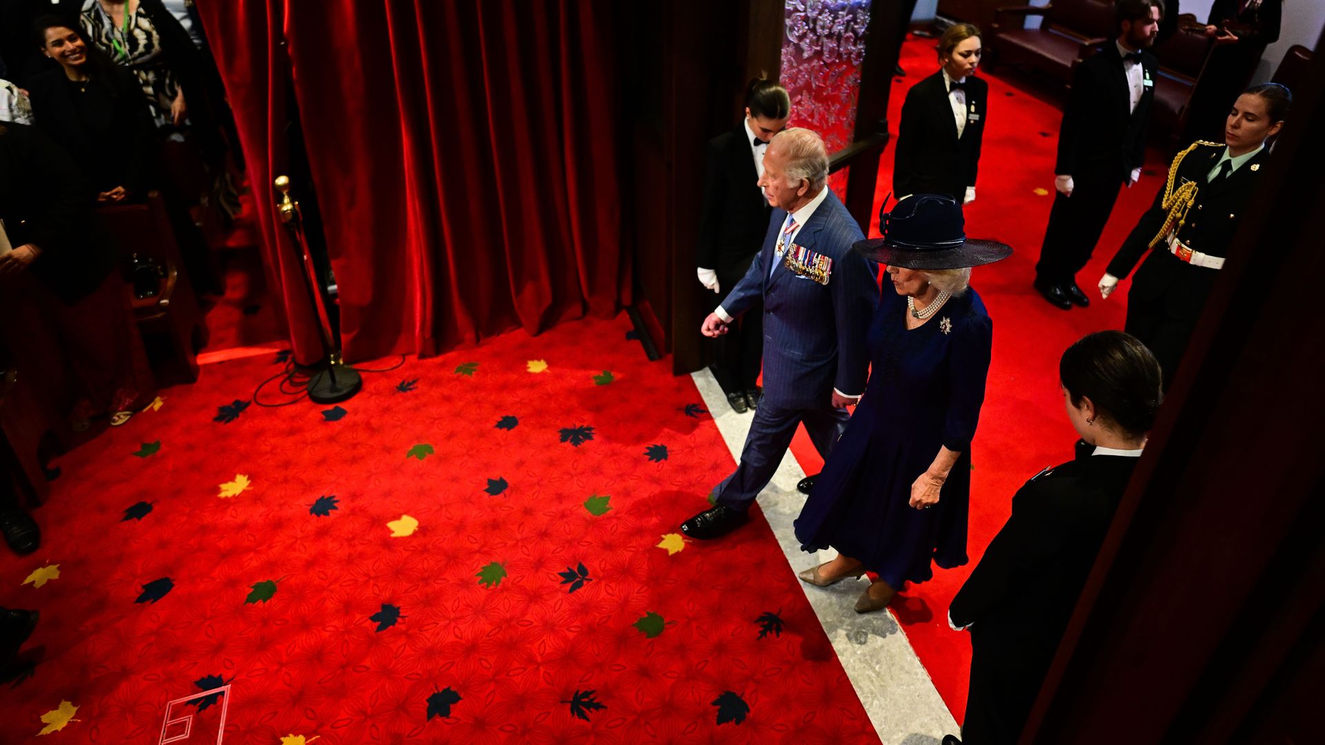 King Charles and Queen Camilla walking through parliament