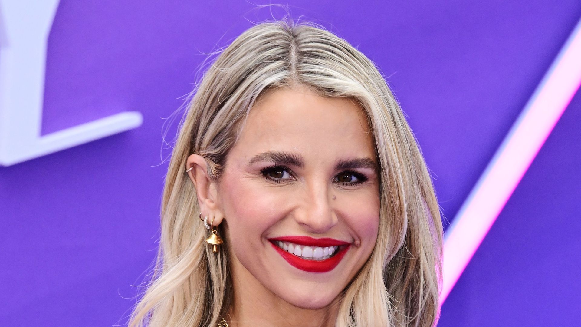 Vogue Williams posed side on in leopard print dress