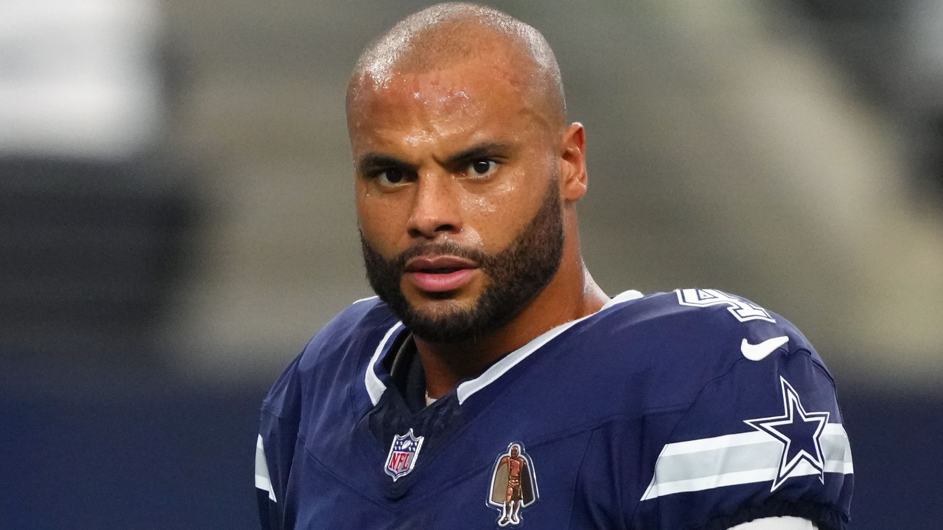 photo of dak prescott holding helmet on the field