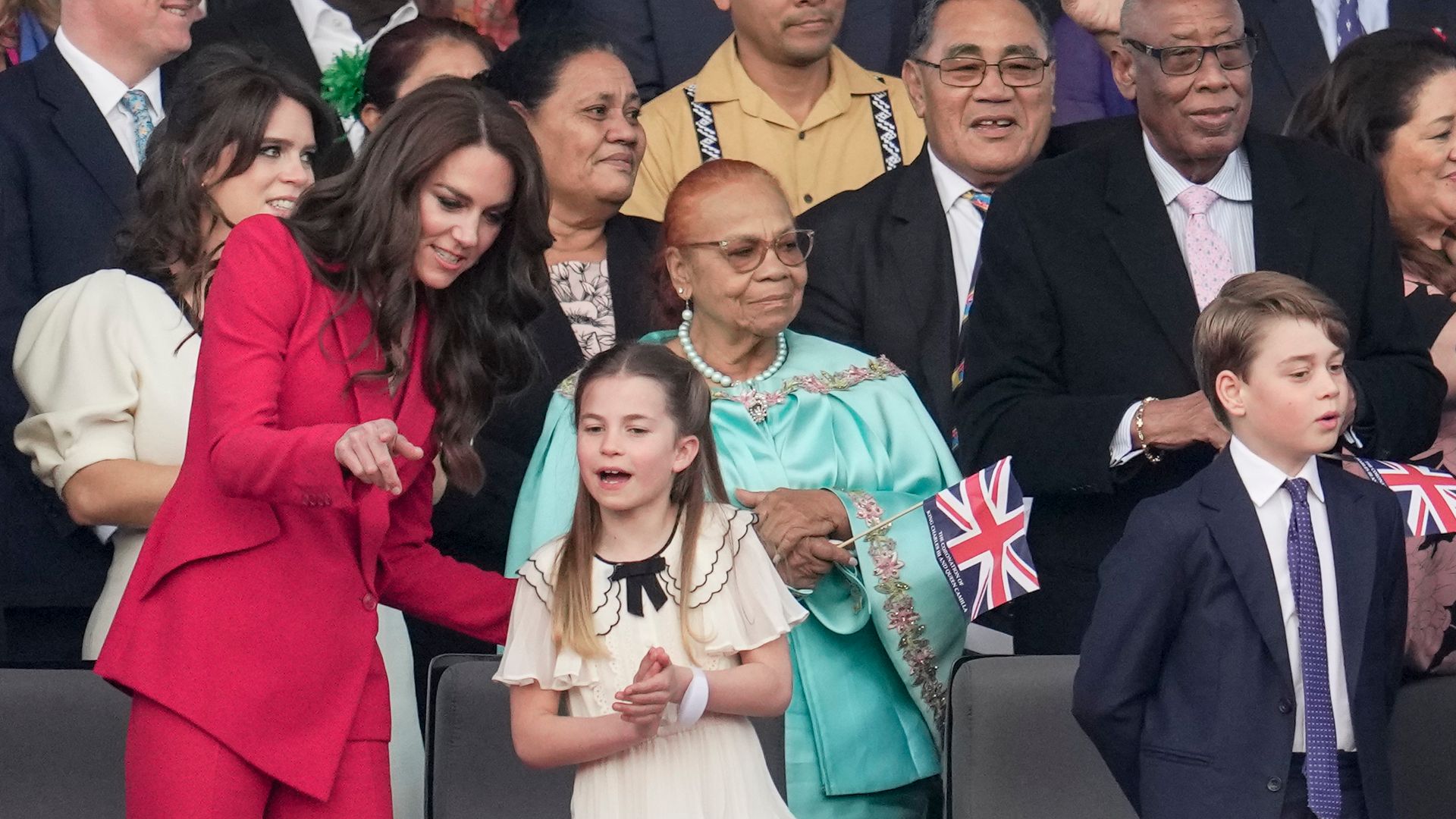 The Princess of Wales points out to Princess Charlotte where her grandparents and auntie are sitting at the coronation concert at Windsor Castle