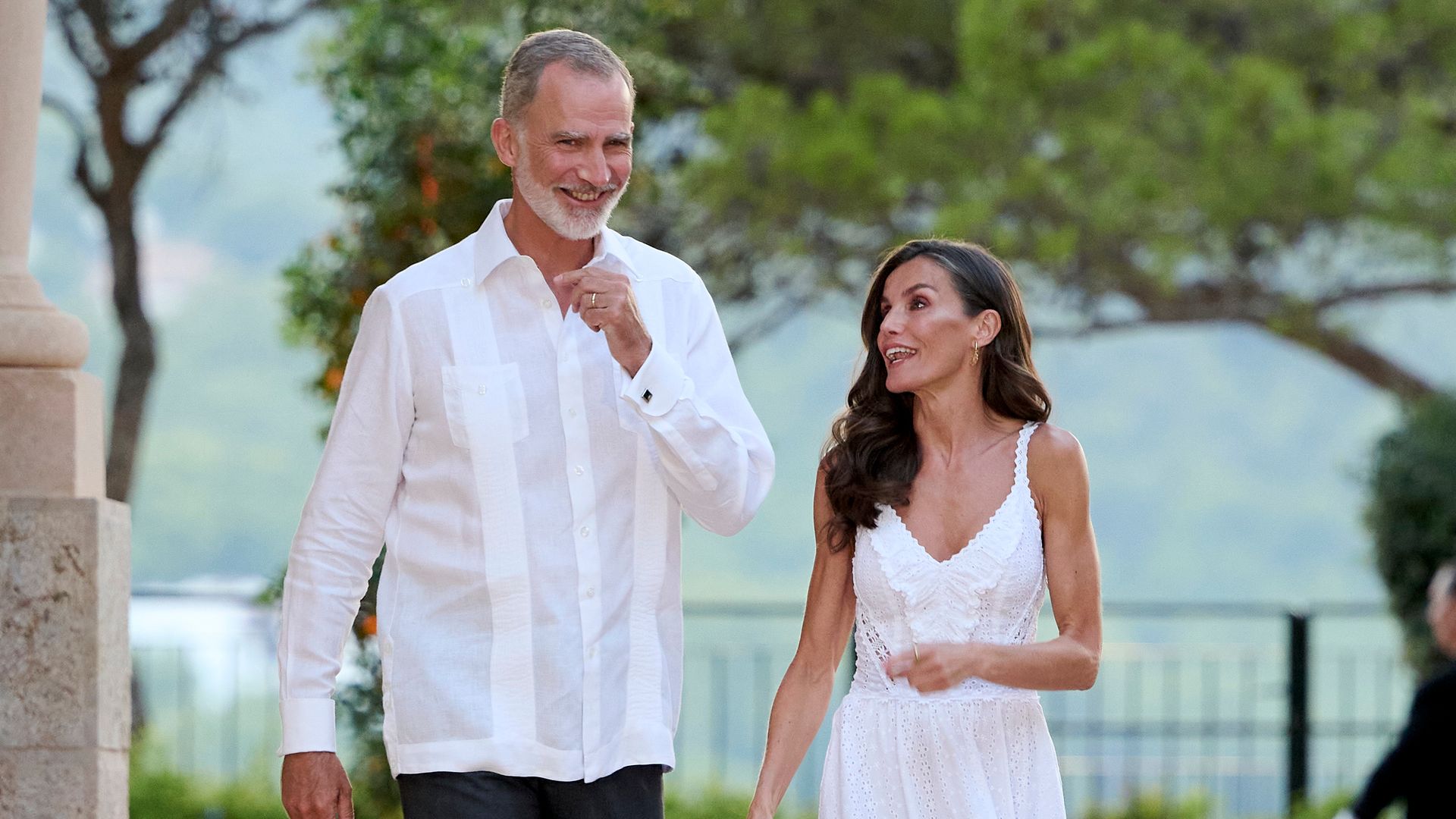 King Felipe and Queen Letizia wearing white and laughing