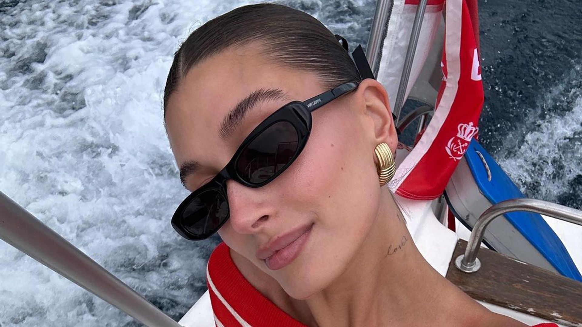 Hailey Bieber in  a red off-the-shoulder top