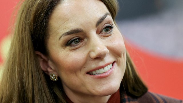 Kate Middleton smiling in checked coat