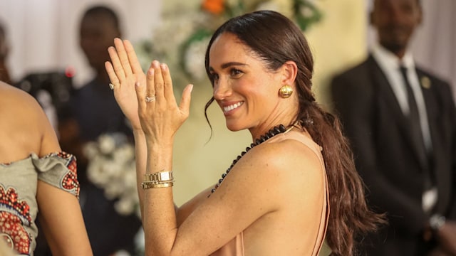 Meghan, Duchess of Sussex, gestures as she arrives with Britain's Prince Harry (unseen), Duke of Sussex, during their visit at the Lightway Academy in Abuja on May 10, 2024 as they visit Nigeria as part of celebrations of Invictus Games anniversary. (Photo by Kola SULAIMON / AFP) (Photo by KOLA SULAIMON/AFP via Getty Images)