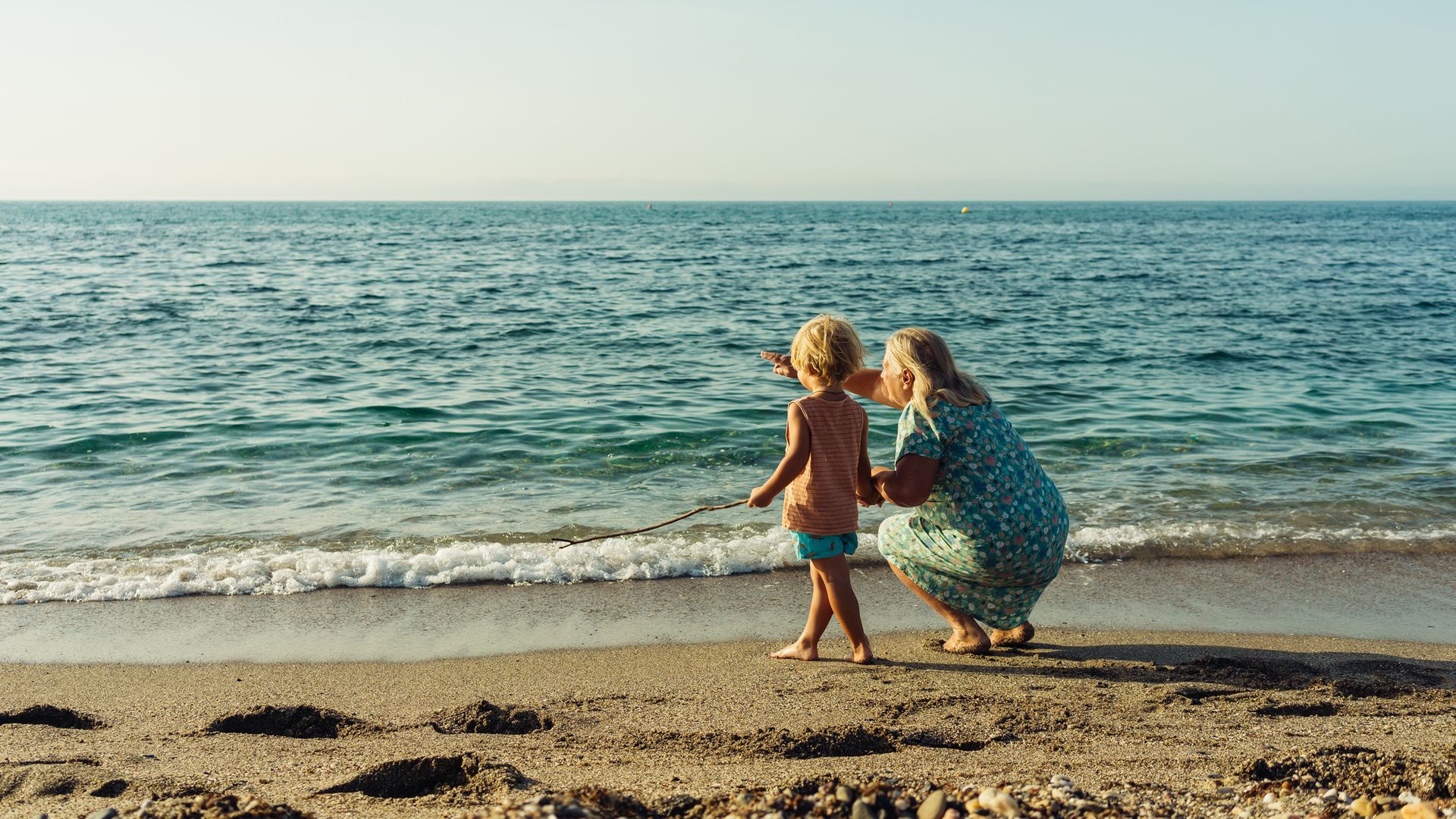 grandmother walks with her grandson on the beach
