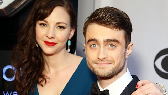 Daniel Radcliffe in a tuxedo and Erin Darke in a blue dress with red lipstick