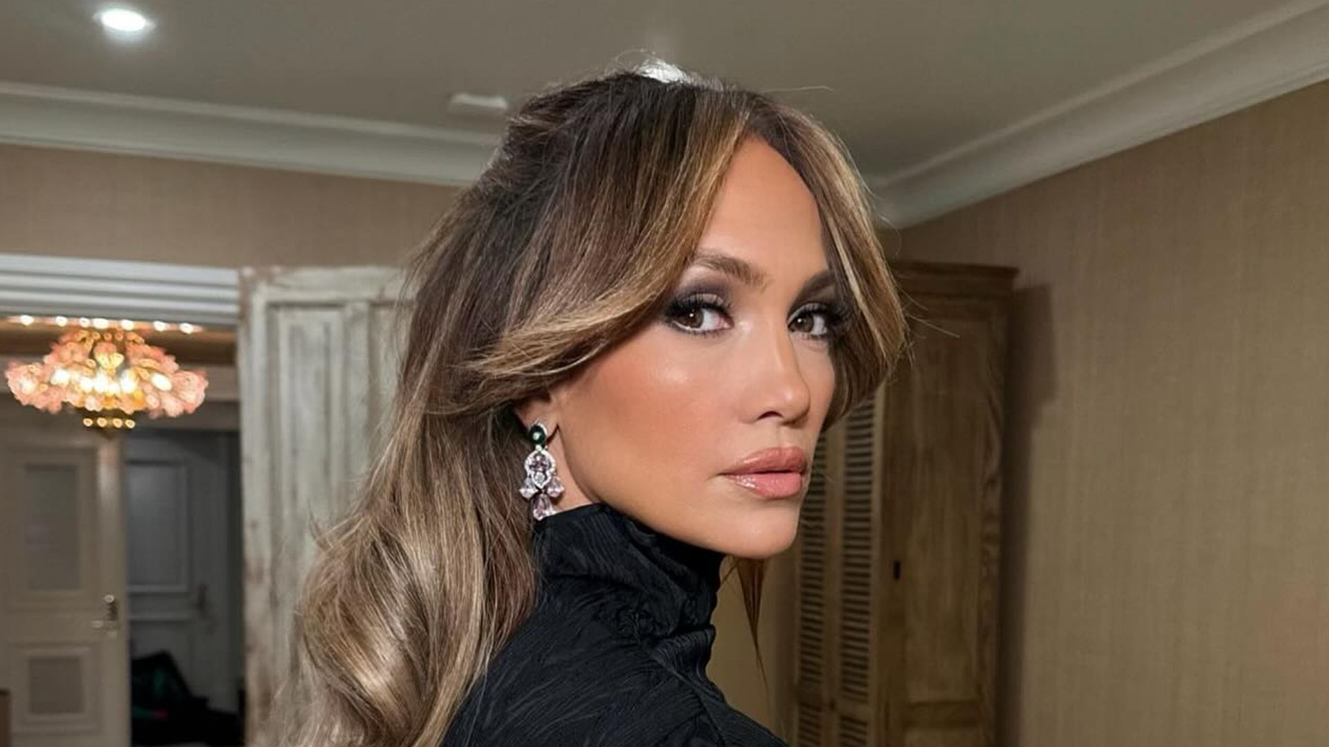 Jennifer Lopez poses in a black turtleneck with diamond earrings on her Instagram