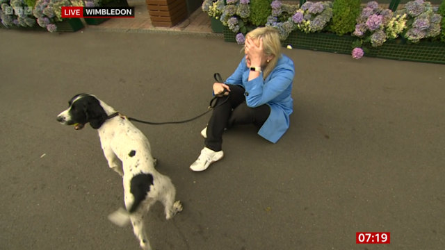 Carol Kirkwood hand on face while holding dog lead