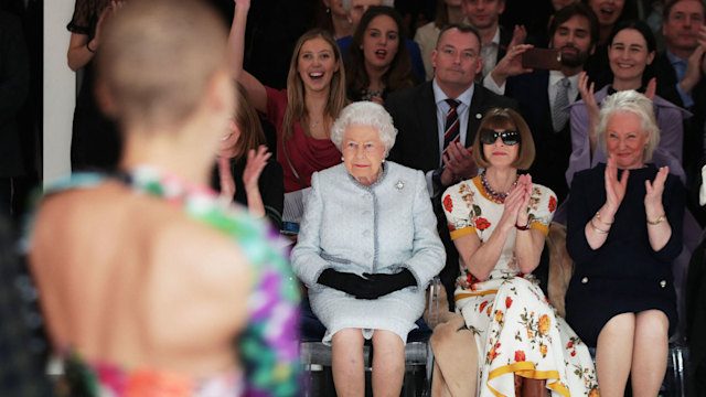 Britain's Queen Elizabeth II, accompanied by British-American journalist and editor, Anna Wintour (3R) and royal dressmaker Angela Kelly, (2R), views British designer Richard Quinn's runway show before presenting him with the inaugural Queen Elizabeth II Award for British Design, during her visit to London Fashion Week's BFC Show Space in central London on February 20, 2018.