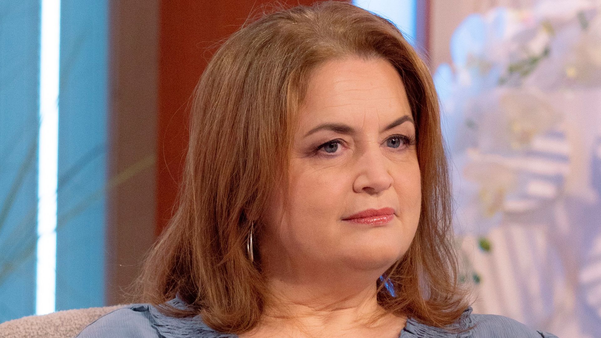 Ruth Jones in chair in blue dress