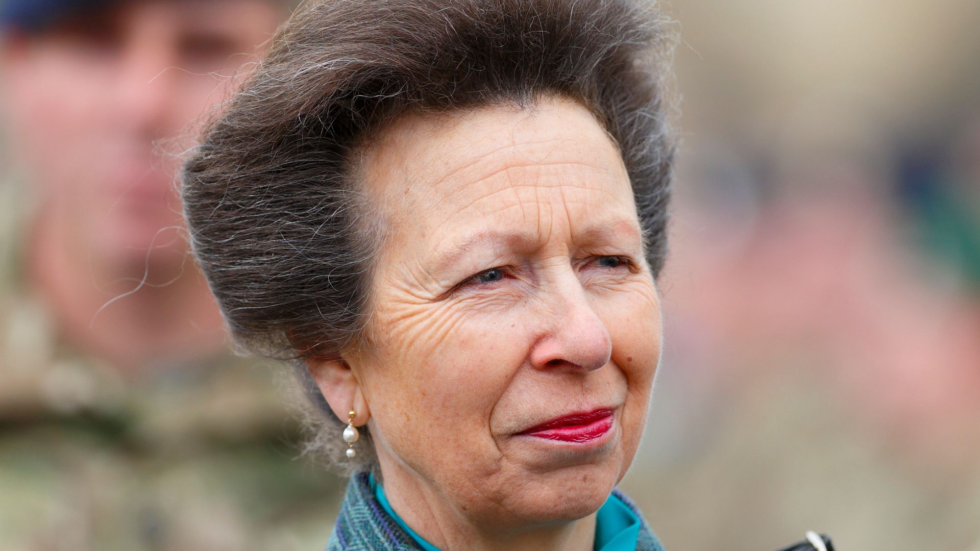 Princess Anne in a green outfit with red lipstick