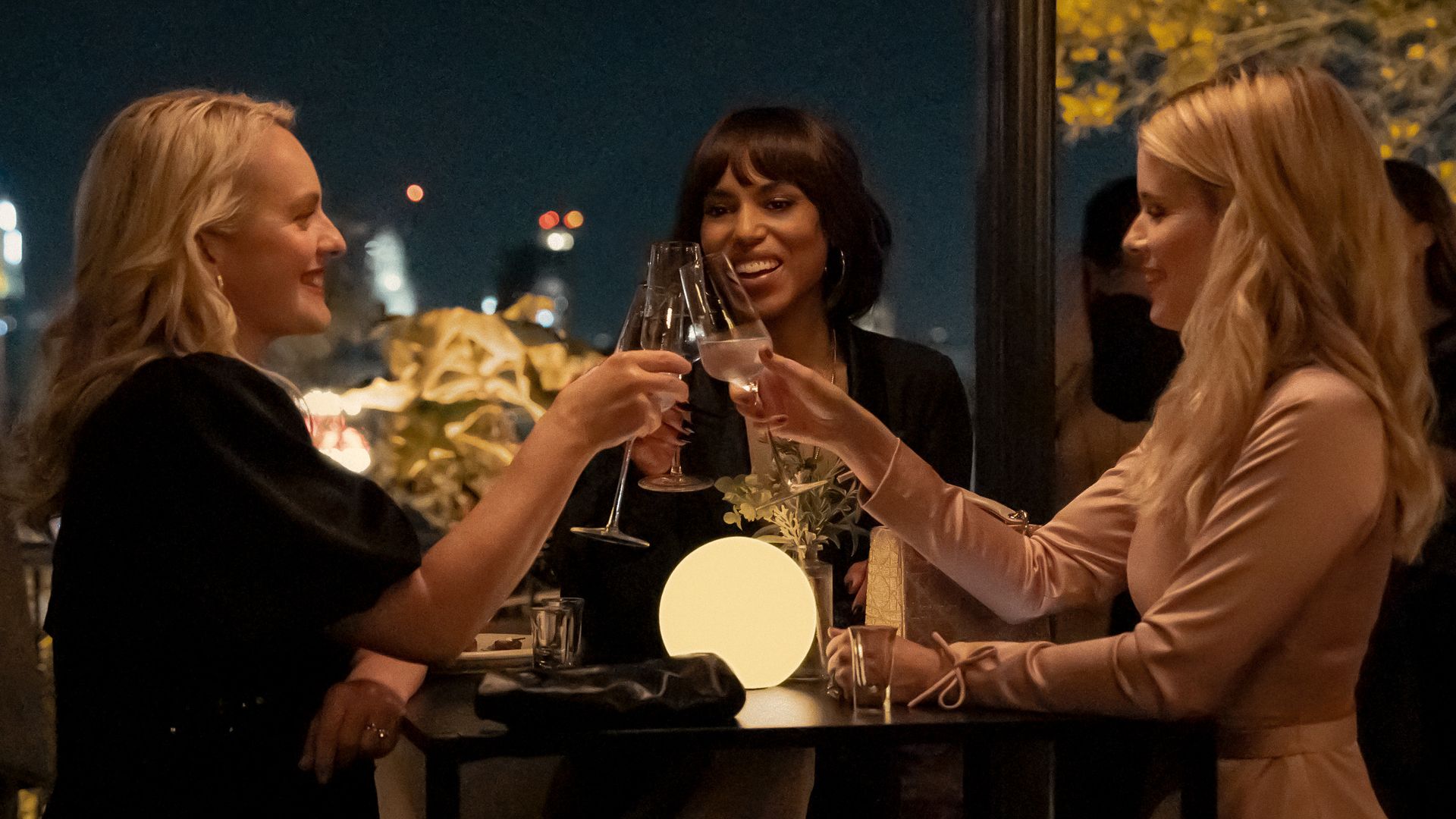 three women clinking glasses at restaurant