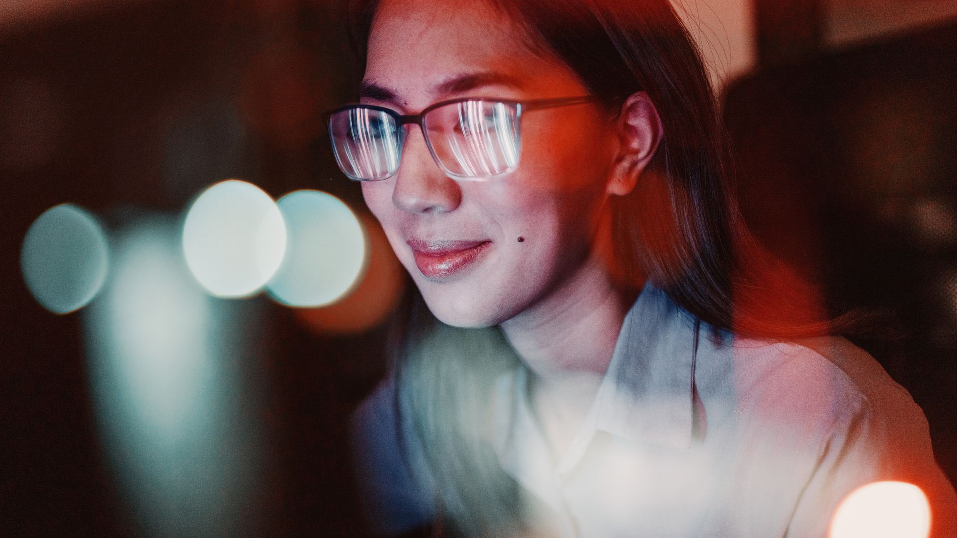 Close-up of a woman with eyeglasses looking at the computer