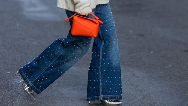 Joicy Muniz wears shirt and sweater Munthe, jeans Munthe, orange bag, oots Bettina Vermillon  Loewe during the Womenswear Fall/Winter 2024/2025 as part of  Paris Fashion Week on February 28, 2024 in Paris, France. 