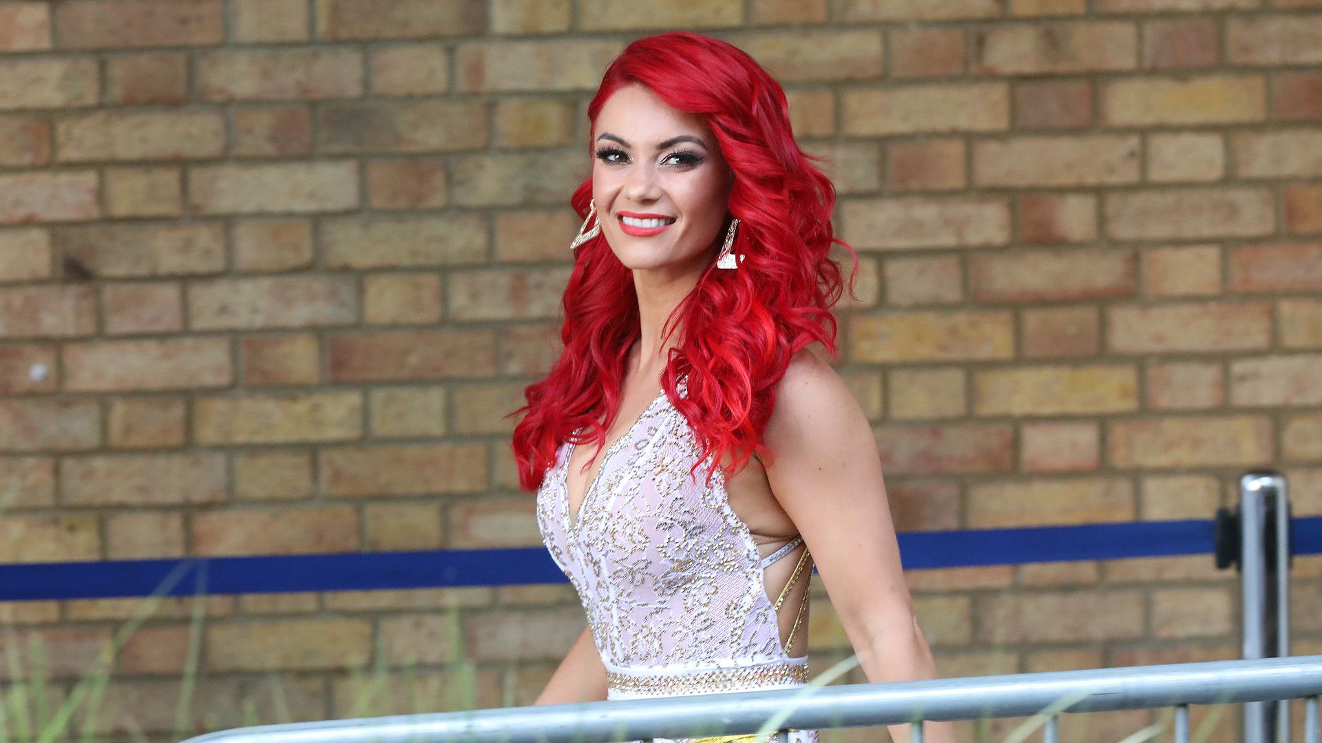 Dianne Buswell smiling in a glittery silver top