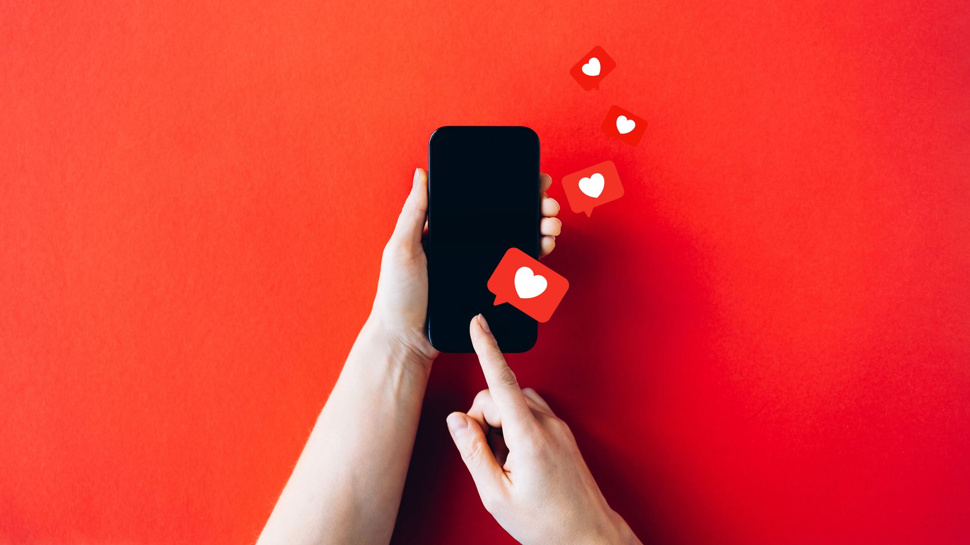 Hands Holding Smartphone with Social Media Love Icons on Vibrant Red Background