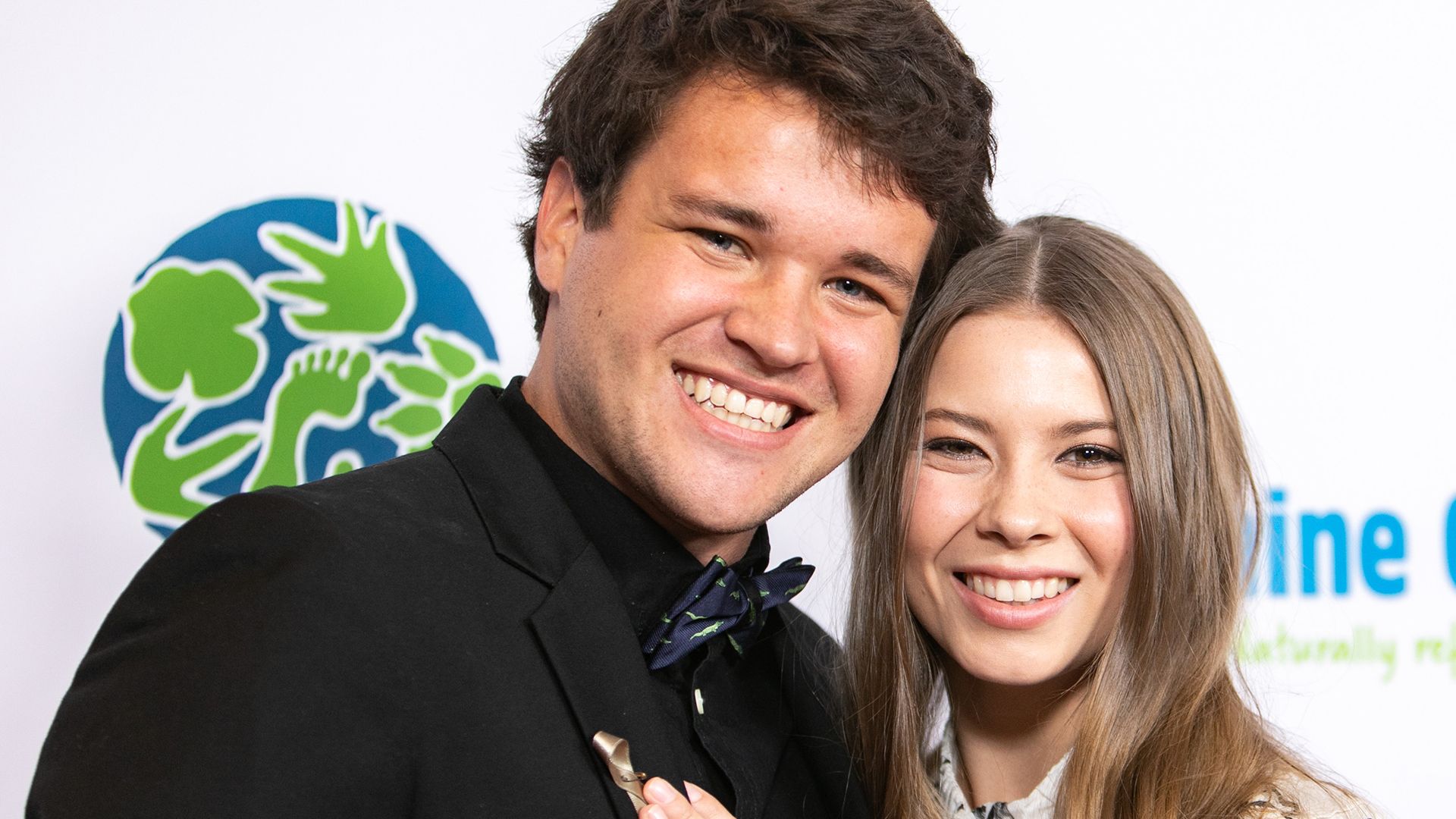 Bindi Irwin looks happy as she places a tender hand on Chandler's chest at an event