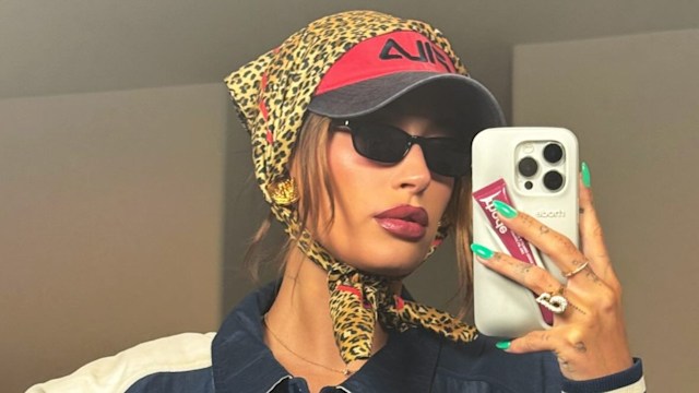 Hailey Bieber poses in a blue jacket, sunglasses, a cap and headscarf 