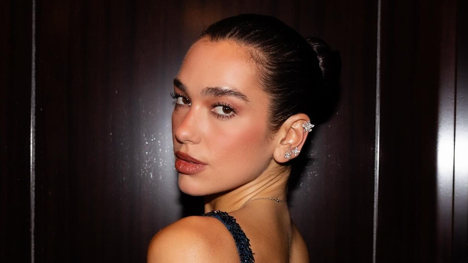 Dua Lipa poses in a navy sequin gown