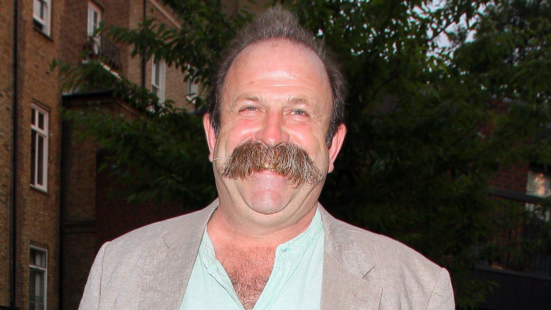 man with moustache walking in London