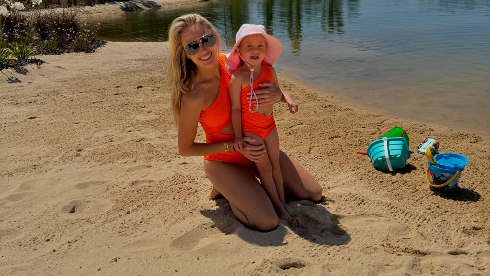 brittany mahomes and her daughter stirling on the beach in neon green swimsuits