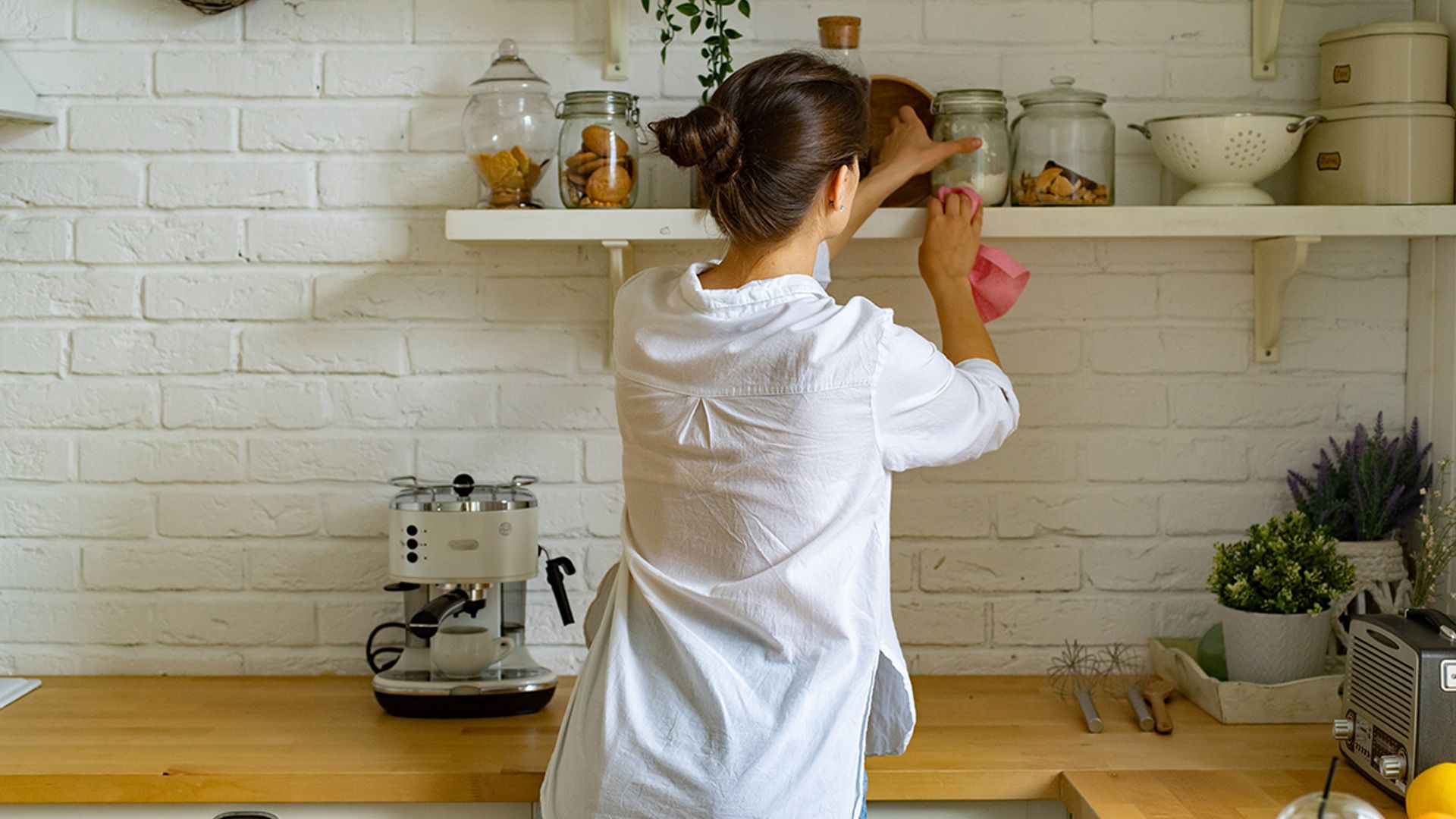 women dusting kitchen shelf