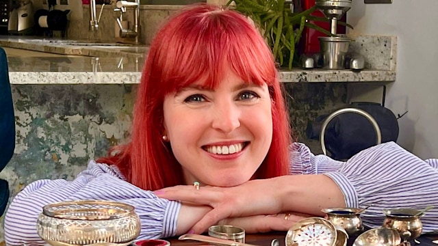 Red-haired presenter with collection of silver spoons
