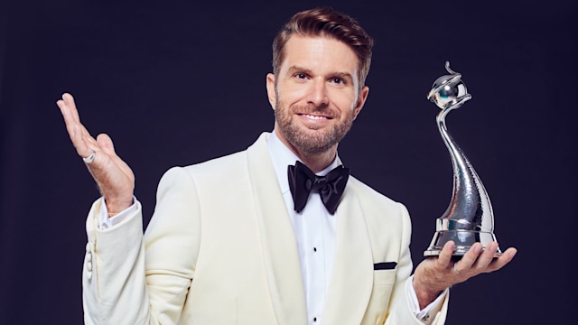 Joel Dommett holding an award