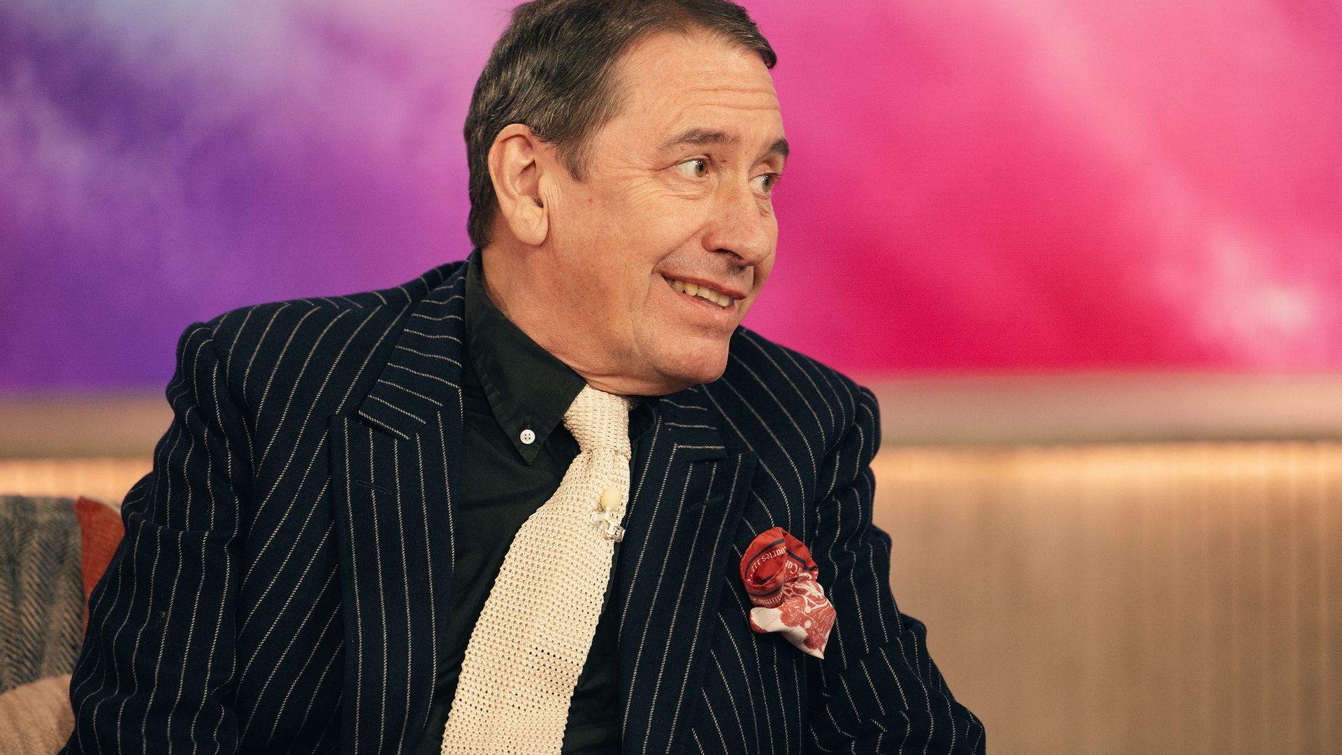 Jools Holland smiling in a pinstripe suit