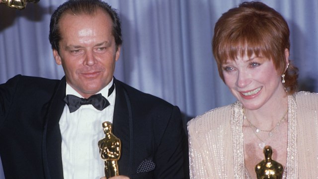 Jack Nicholson and Shirley MacLaine pose together in front of a blue curtain, holding their Oscars for director James L Brooks'  film, 'Terms of Endearment' at the Academy Awards