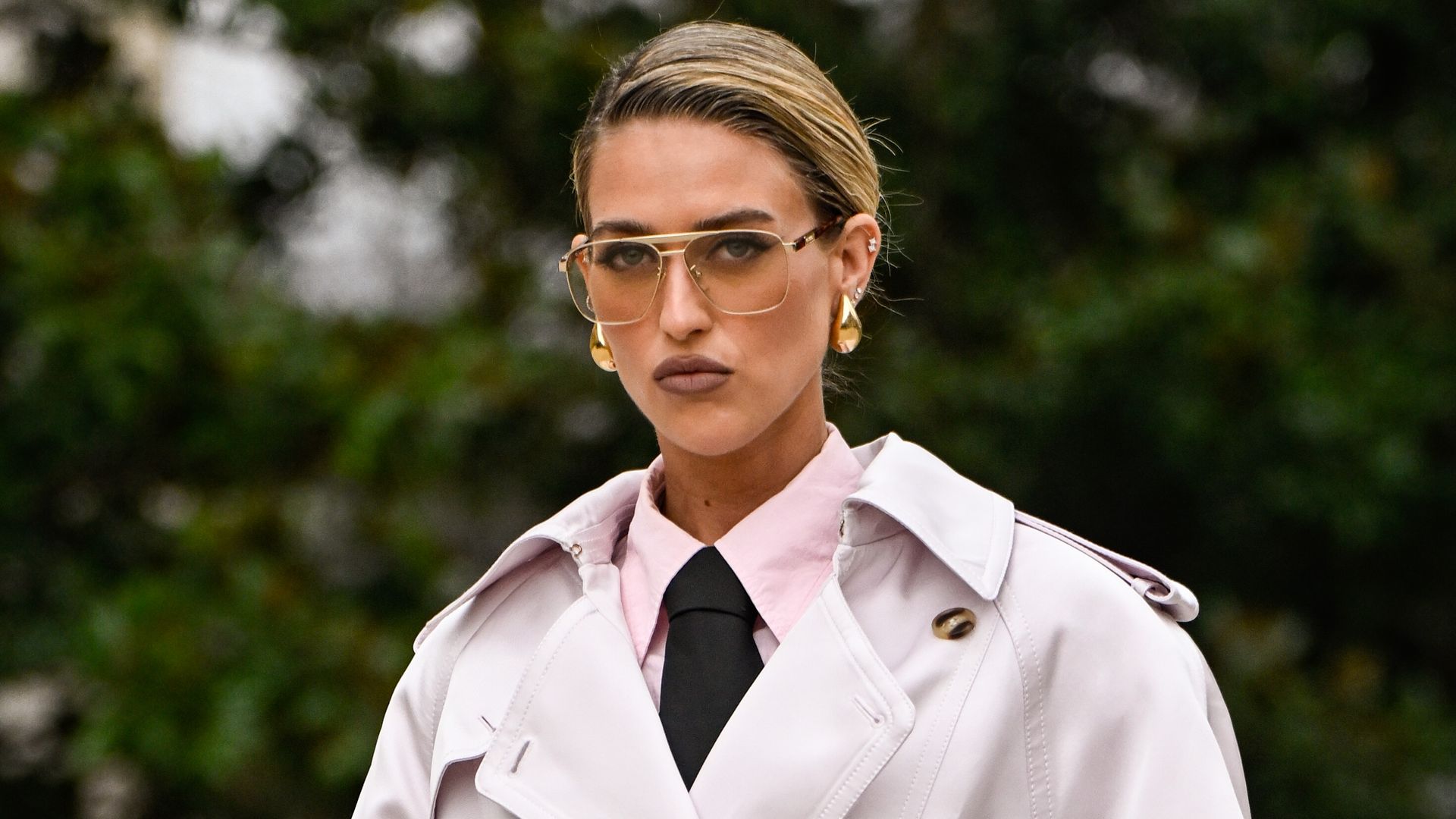 Emili Sindlev is seen wearing an ivory trench coat, pink shirt, black tie, pink pants, black heels and black Hermes bag outside the Zimmermann show during the Womenswear Fall/Winter 2025/2026 as part of Paris Fashion Week on March 10, 2025 in Paris, France. (Photo by Daniel Zuchnik/Getty Images)