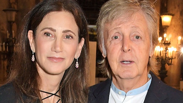 Nancy Shevell in a black dress with Sir Paul McCartney in a suit as he points at the camera