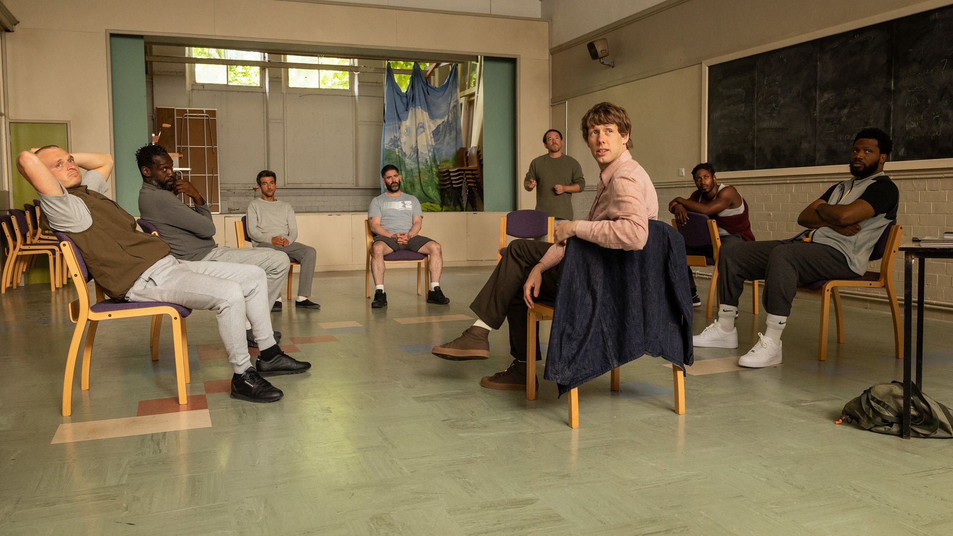 Josh Finan speaking to a group of prisoners in a scene from Waiting for the Out