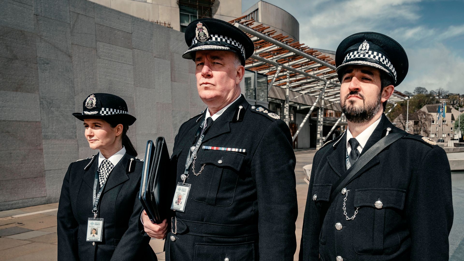 three police officers standing on street