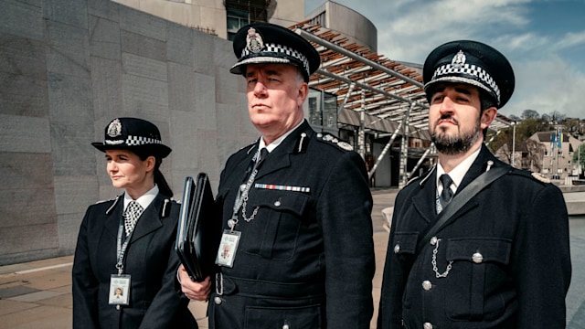 three police officers standing on street
