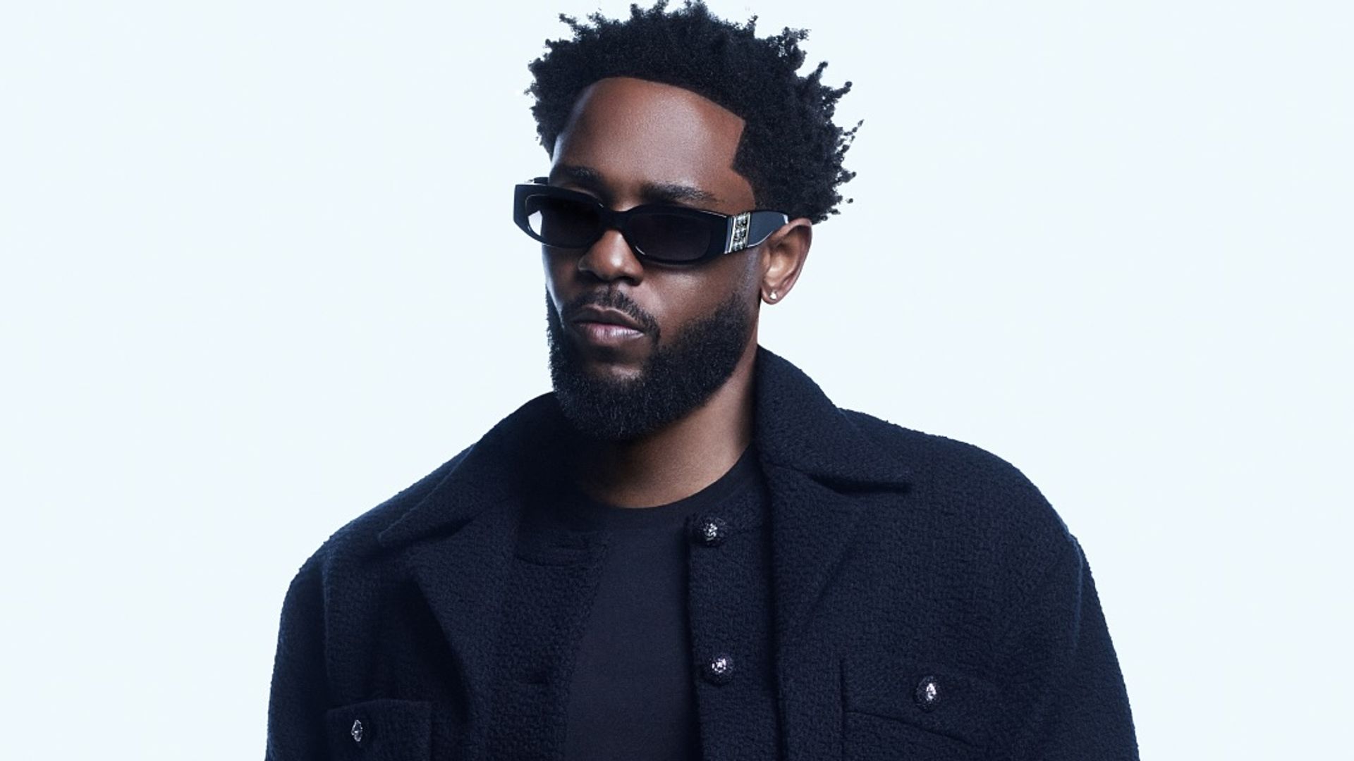 An image of Kendrick Lamar wearing a pair of Chanel sunglasses with a navy bomber jacket and jeans