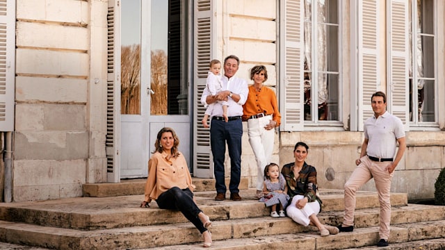 Baron Arnaud de Bastard posing with family outside Chateau de Saint-Denis 