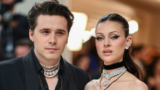man and woman standing straight faced next to one another